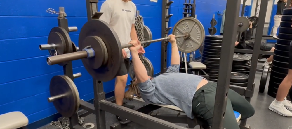 Strength and Conditioning class student attempts to lift weights