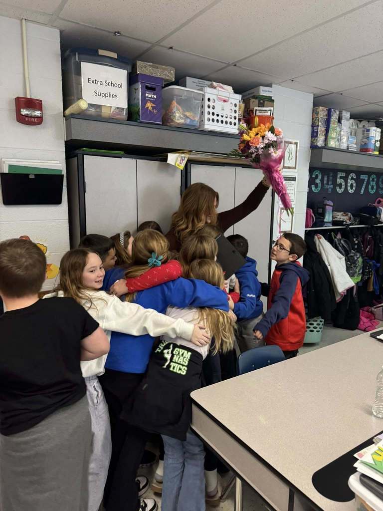 Image of Mrs. Ray with more students hugging her