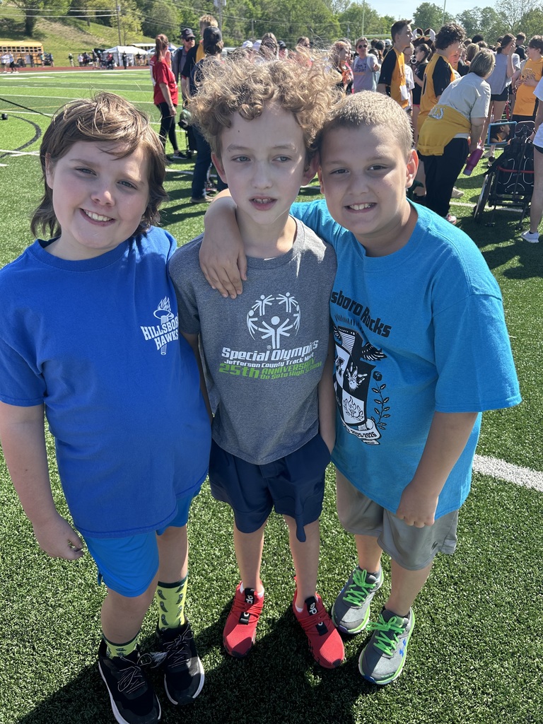 three students smiling at the camera during the special olympics in De Soto