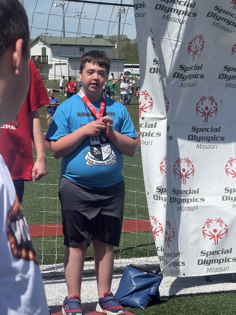 image of a student standing at the podium after receiving a medal during the special olympics in de soto
