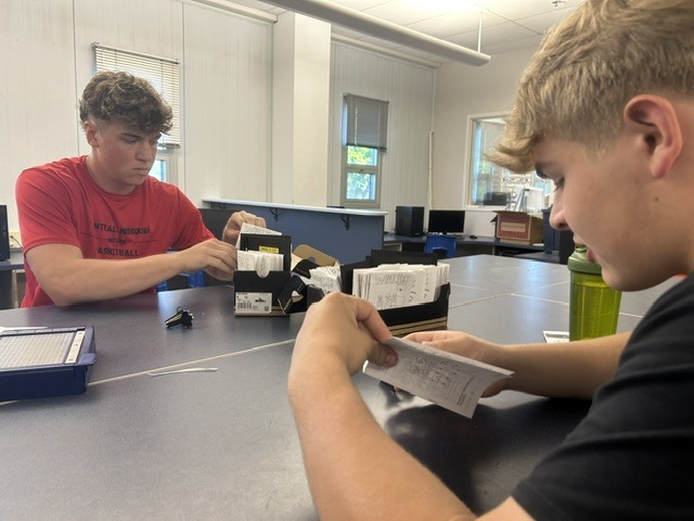 Students check for quality control of each comic book before it is tucked into a box.