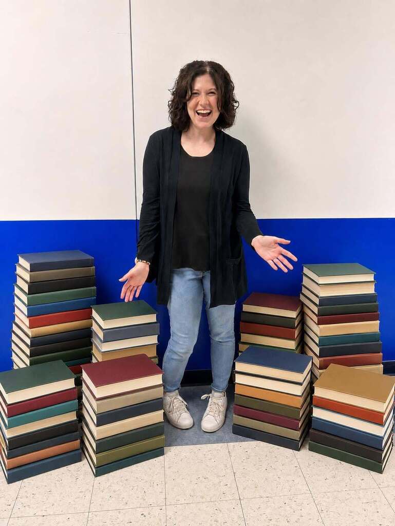Mrs. Kalista standing with a stack of library books