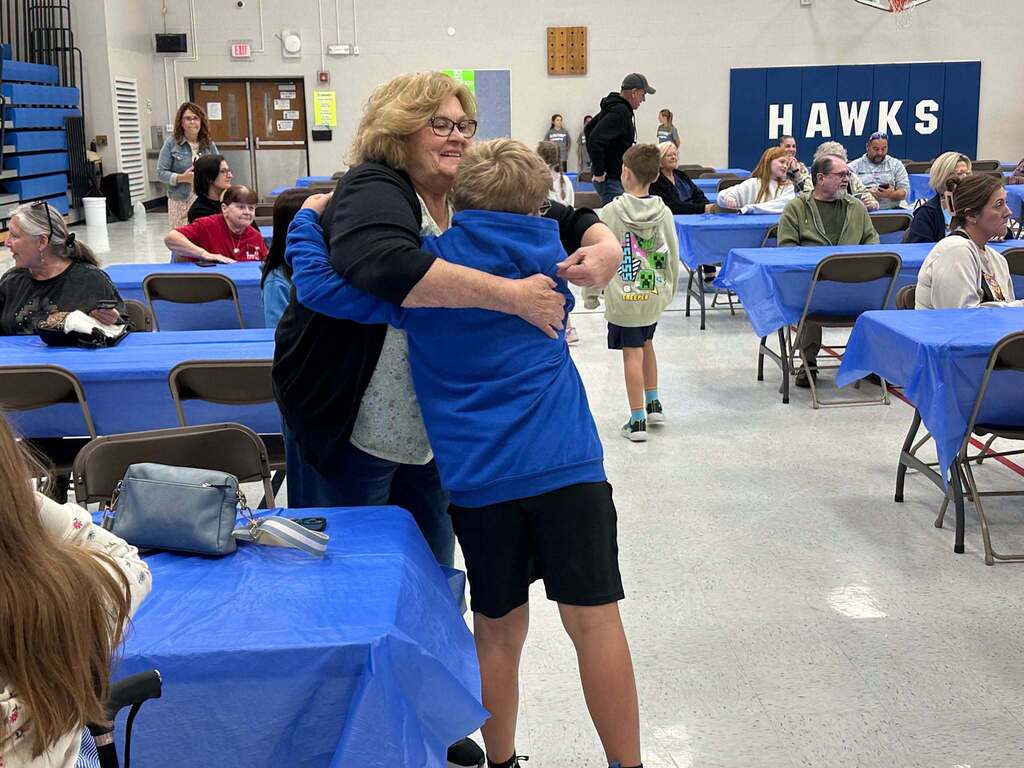 image is of students hugging their grandparents during grandparents day at the intermediate school
