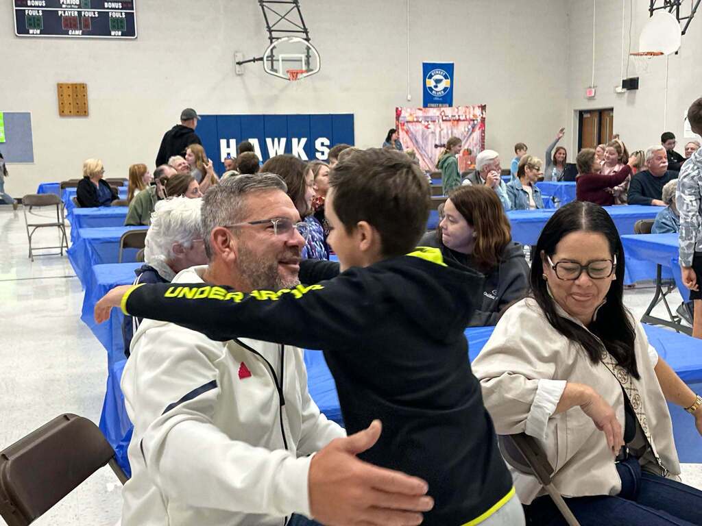 image is of students hugging their grandparents during grandparents day at the intermediate school