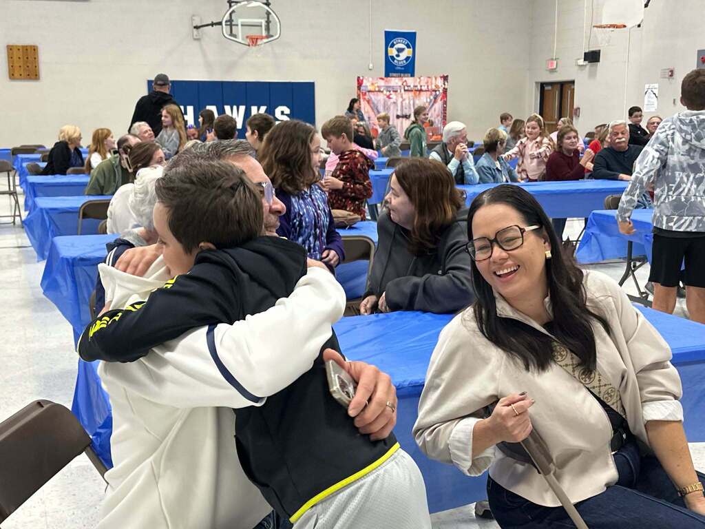 image is of students hugging their grandparents during grandparents day at the intermediate school