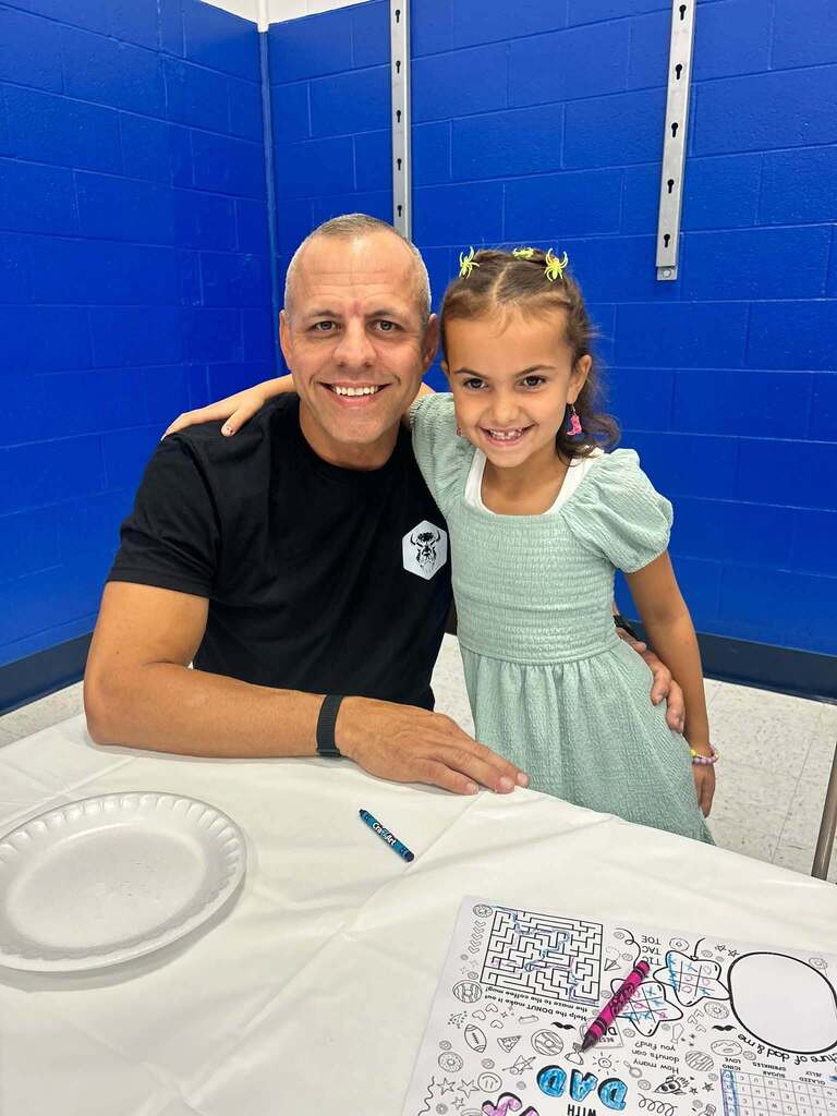 student with their dad on dad and donuts day