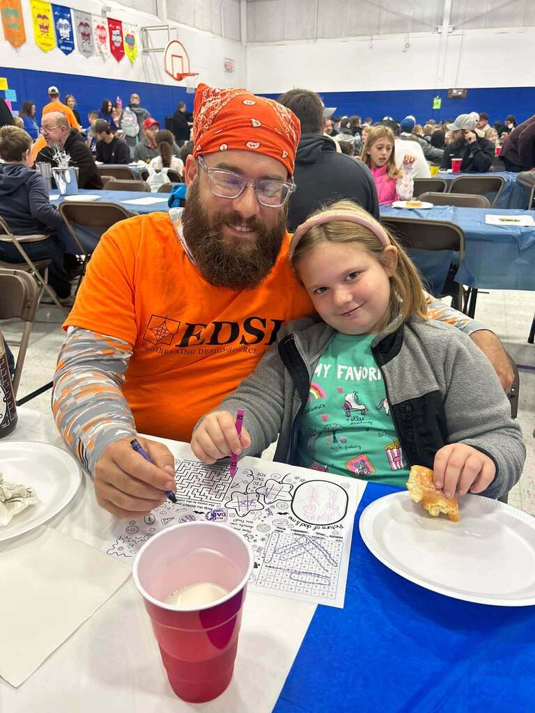 student with their dad on dad and donuts day