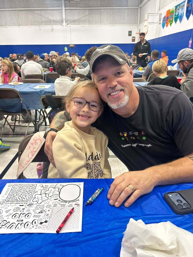 student with their dad on dad and donuts day