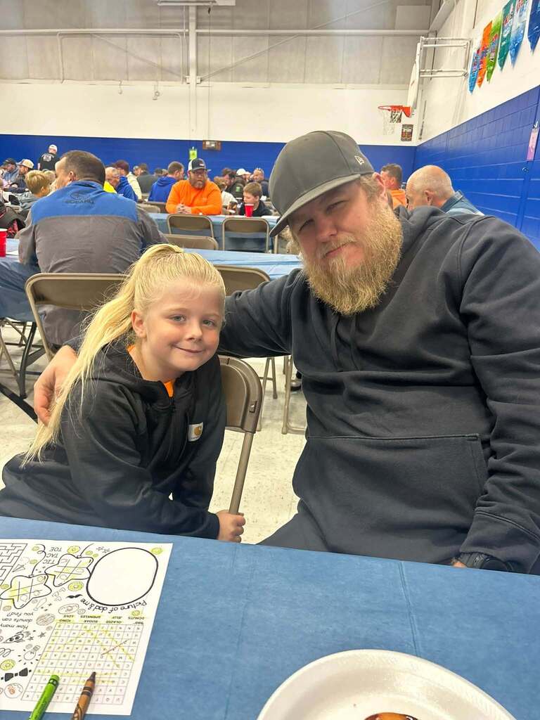 student with their dad on dad and donuts day