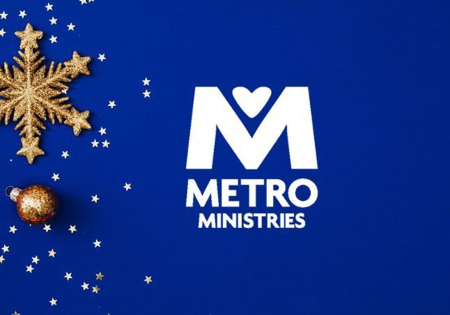 Blue background with gold snowflake, stars and ornament. White Metro Ministries logo