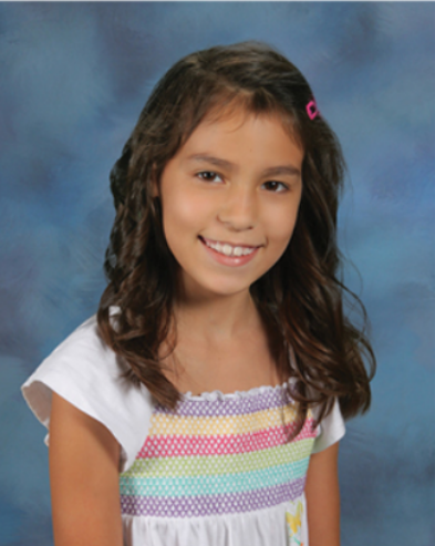 Student smiling for school picture on a blue background