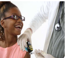 Person in pink with dark skin, being administered a shot in her arm by a figure in a medical lab coat and a stethescope aroujnd their neck