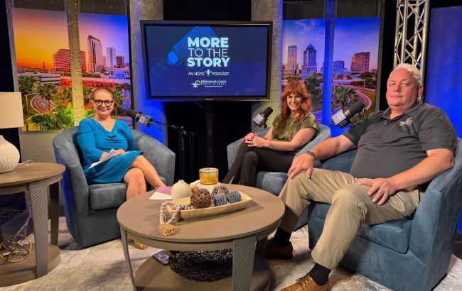 3 people sitting on a tv set