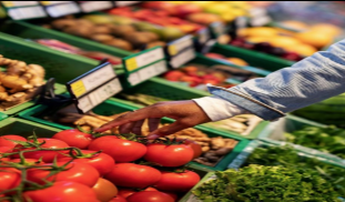 an african american hand reaching for a tomato from a vegetable stand