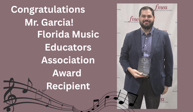 mauve background; treble clef with music waving along the bottom of the page; person with brown beard and hair smiling at the camera, holding a clear award, wearing a checkered button down shirt and a gray suit