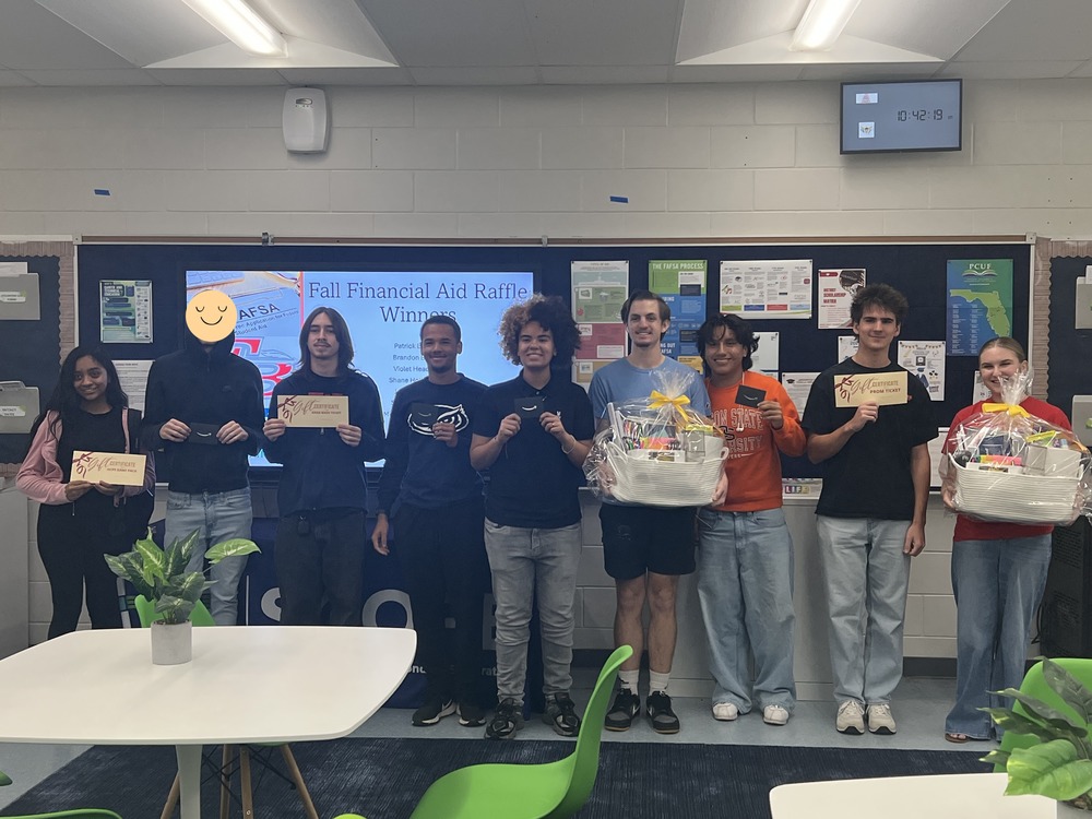 Students standing in a line holding prizes that they won