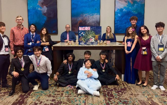 smiling students posing after winning at a competition.