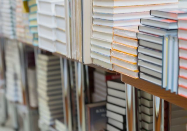Multi colored books stacked on shelves