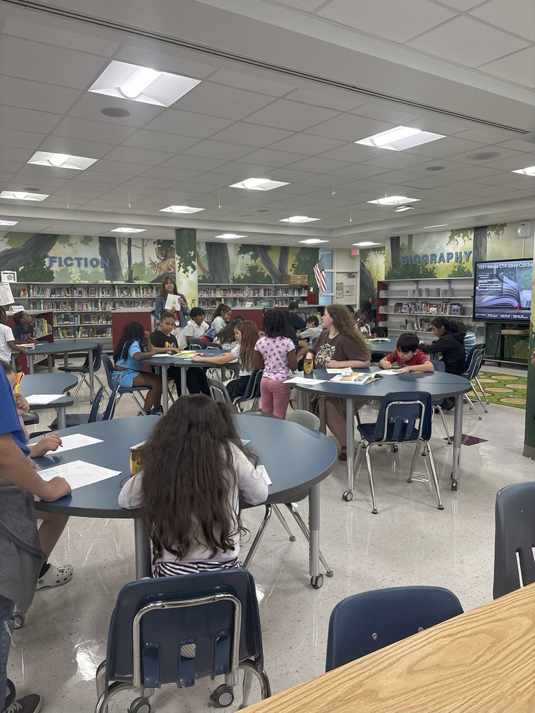 Students Reading Books to younger students