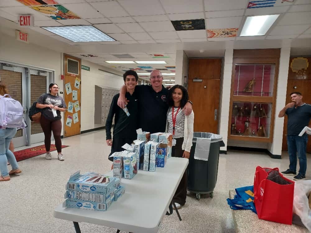 Mr. Risher and students posing near the ice cream table