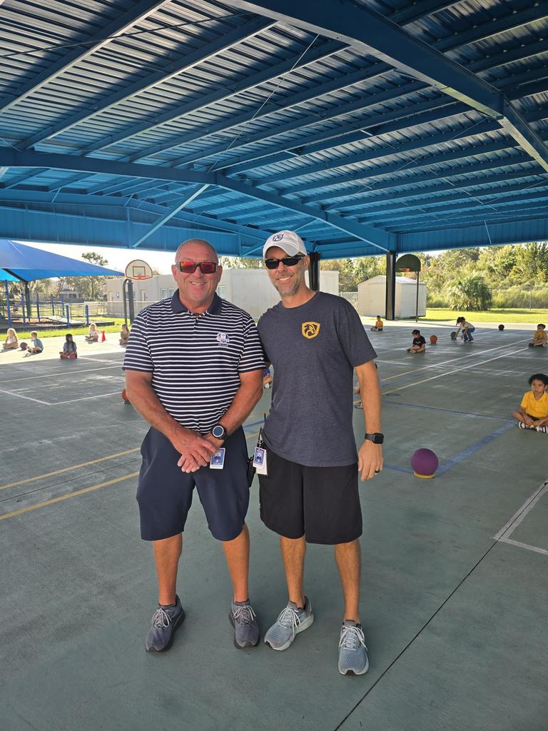 Photo of Coach Judd and Thompson outside under the covered court