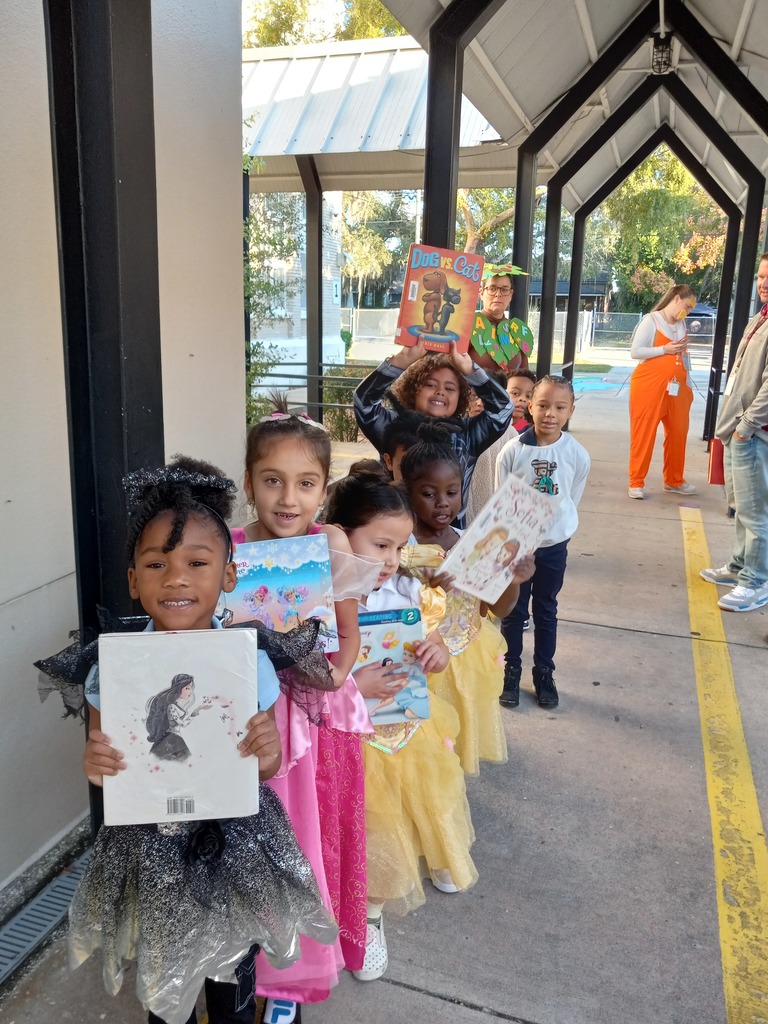 Students in costumes holding books.