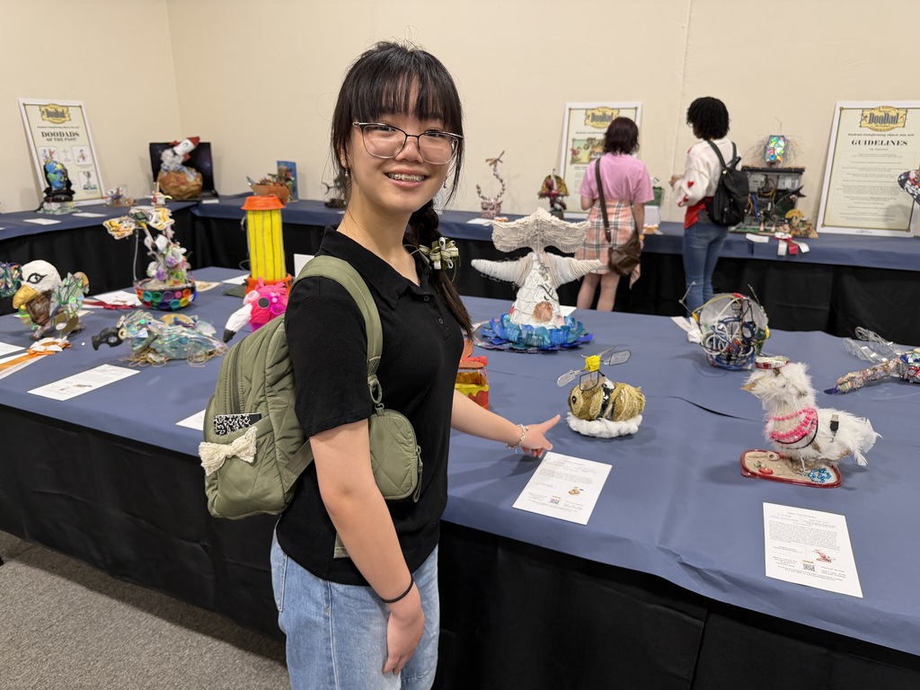 Student showing off her art piece