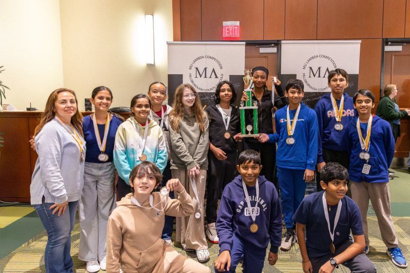 Students standing with teacher taking pictures for the 3rd place Finish in the Math Bowl