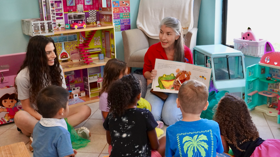 Teacher reading to students at 1Voice ceremony