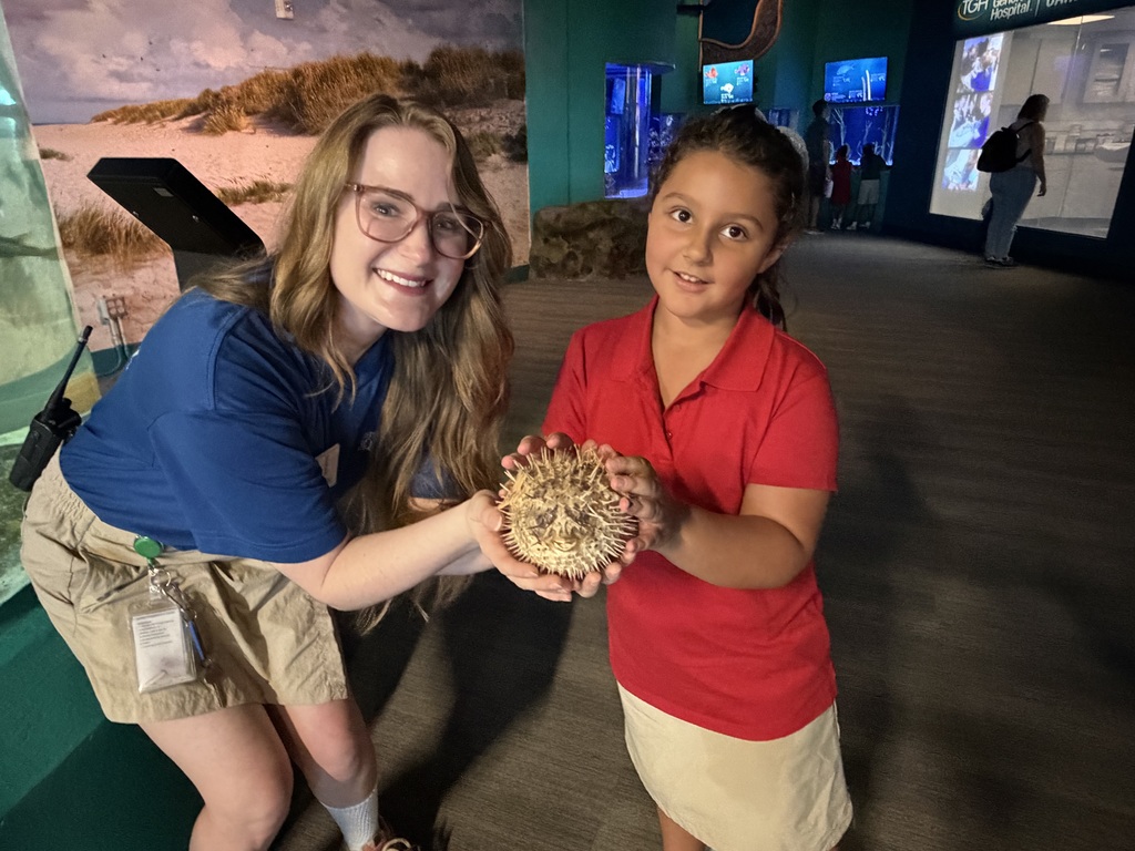 Female and young student holding a pufferfish