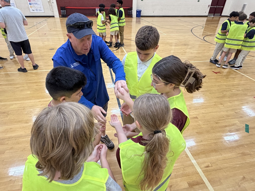 Group of students standing in a circle and working together through an activity