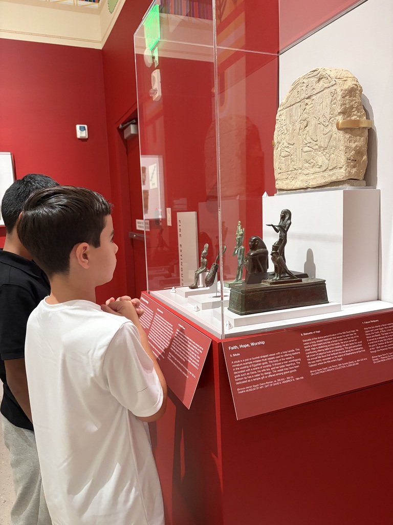 Male student looking at an art piece in a glass case