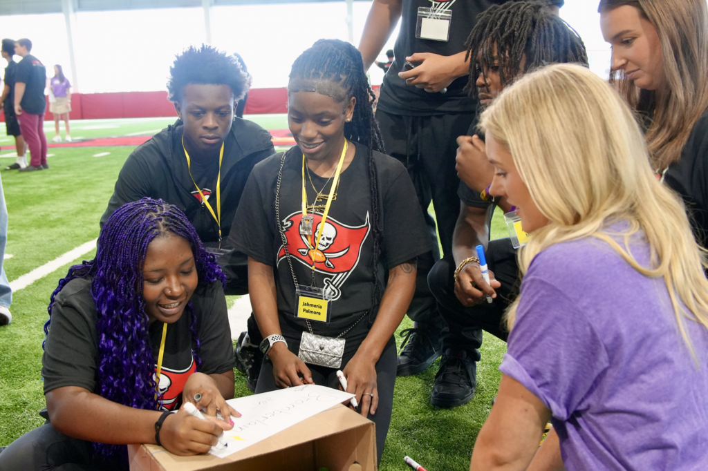 Students, cheerleader, and volunteer  at Student-Player Mentoring Program