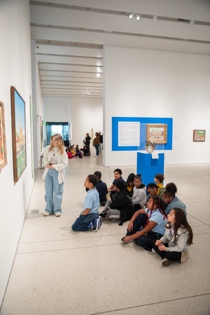 Group of students looking at a wall of art in a museum