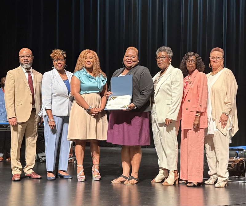 Teacher receives recognition for outstanding contributions during the August Board of Directors meeting.