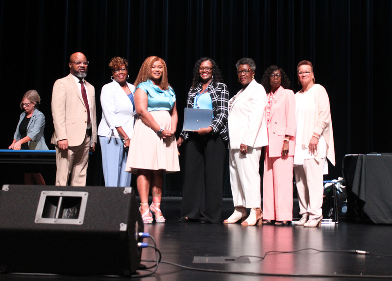 Teacher receives recognition for outstanding contributions during the August Board of Directors meeting.