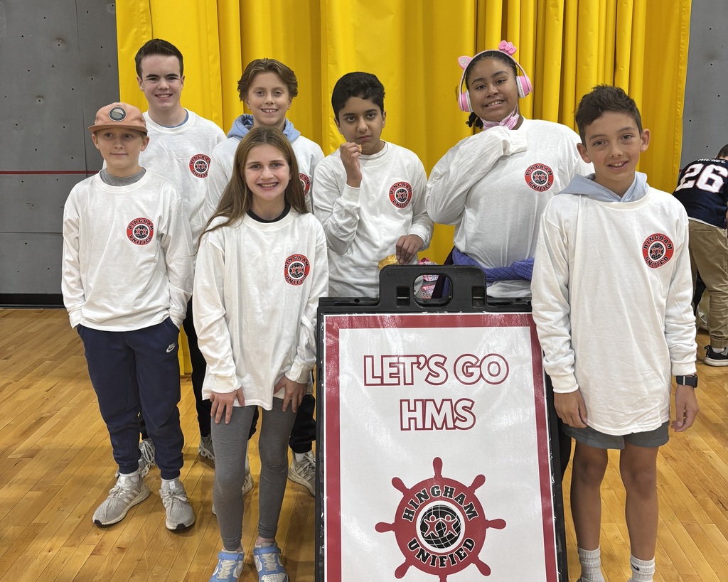 middle school unified players posing in their white team tshirts with a sign that says lets go HMS Hingham Unified.