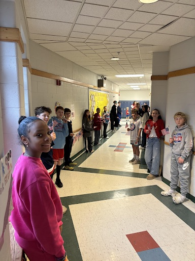 student smiling at the camera lining the halls.