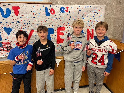 for students, smiling and waving American flags.