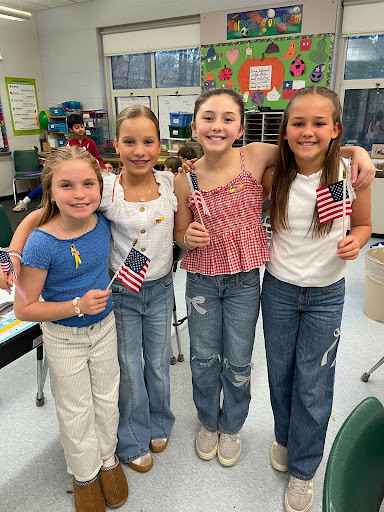 for student, smiling, and waving American flags.