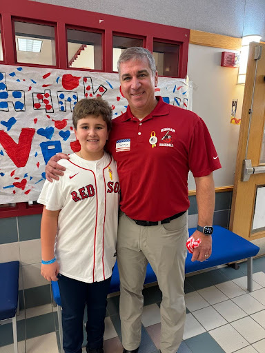 A student and parent veteran stand together and smile.