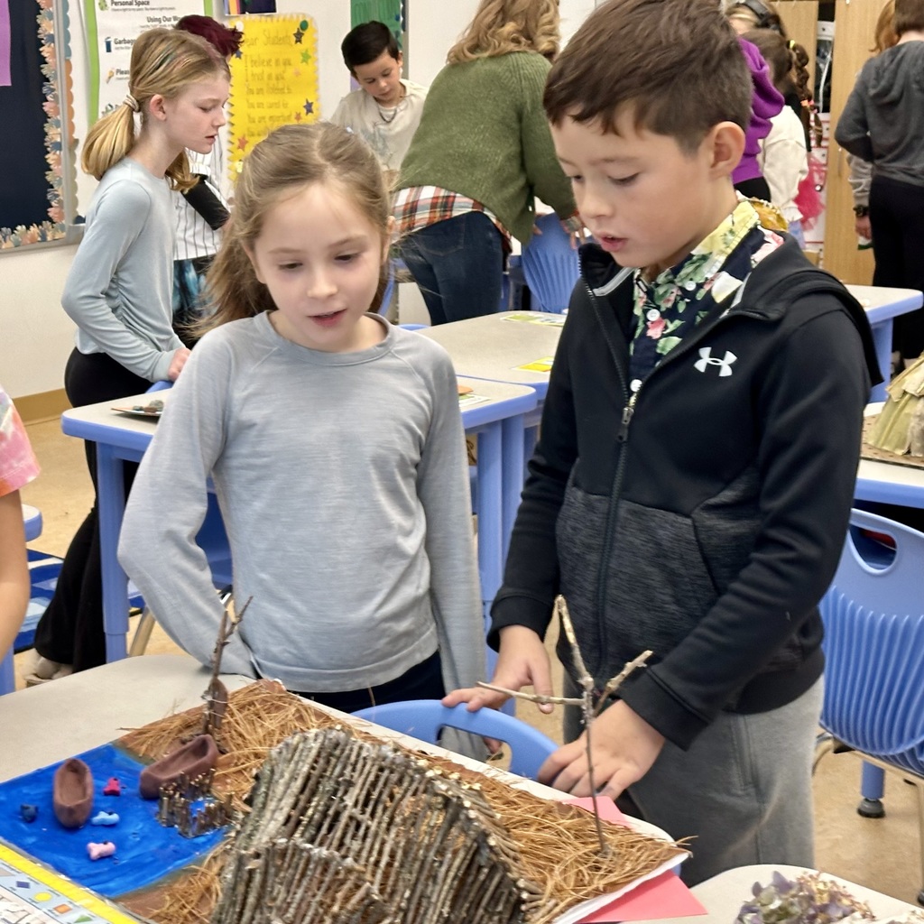 Student showing off his wetu creation to other students during the walkthrough.