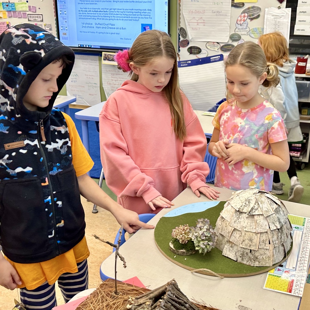 Student showing off her wetu creation to other students during the walkthrough.