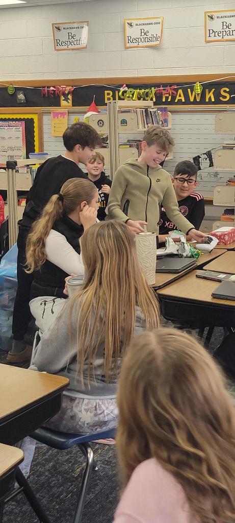 6th graders in Language Arts class opening presents for the gift exchange writing activity.