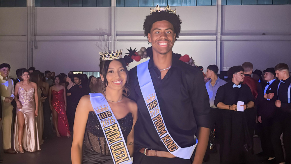 two students with prom king and queen crowns