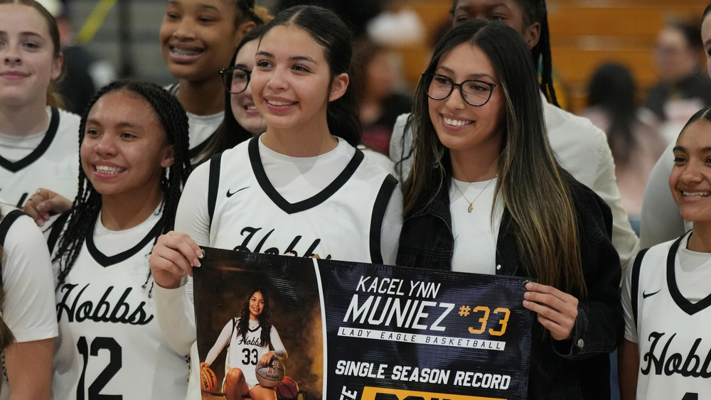 two players posing with banner