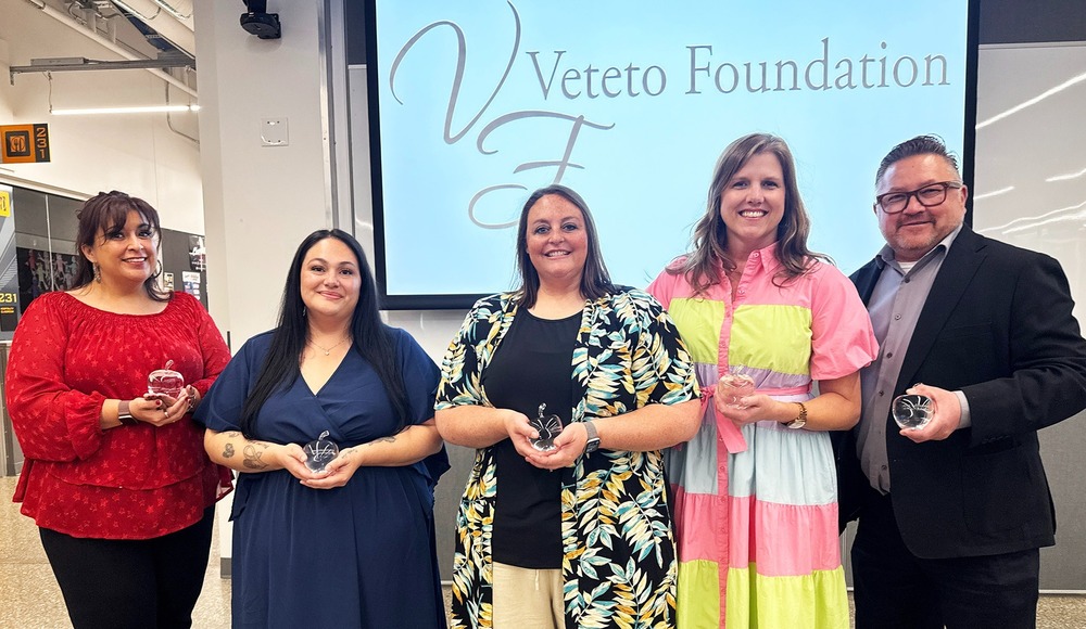 5 people standing with awards