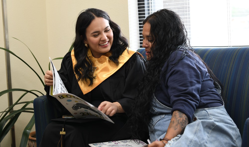 senior and parent looking at yearbook
