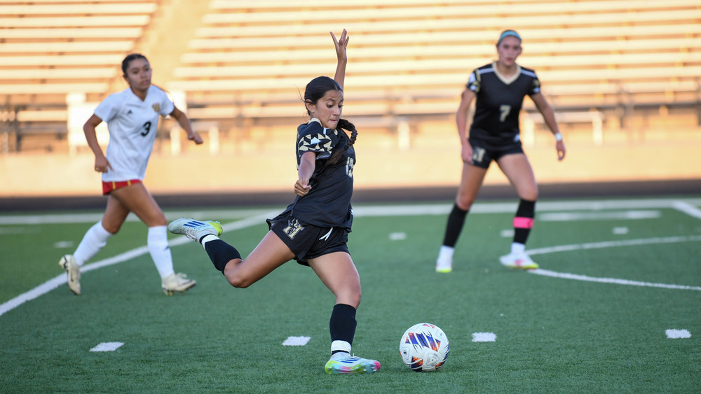 girl player kicking soccer ball