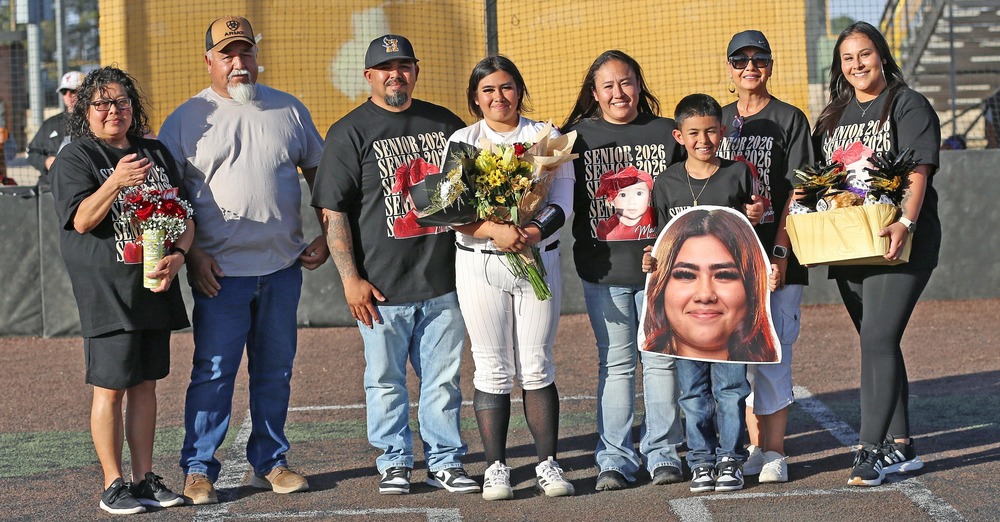 family posing with softball player